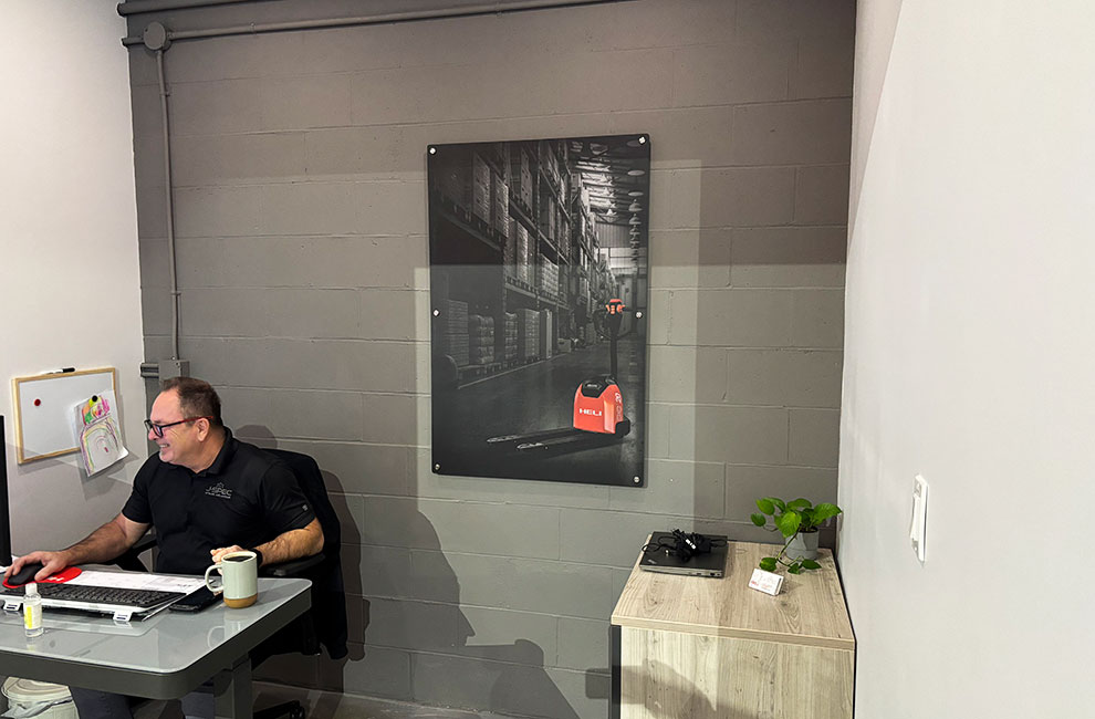 Bureau de représentant avec une affiche au mur d'un transpalette électrique de Heli