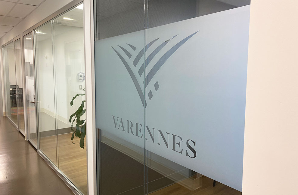 vue en angle des portes vitrées d'un bureau couvert partiellement d'une pellicule givrée dans laquelle on a fait une découpe du logo de la ville de Varennes